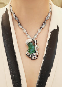 An elegant female wearing a stunning 68carat natural Columbian rock emerald pendant on brilliant diamond and icy white jadeite necklace, both handmade by www.jingyayi.com.